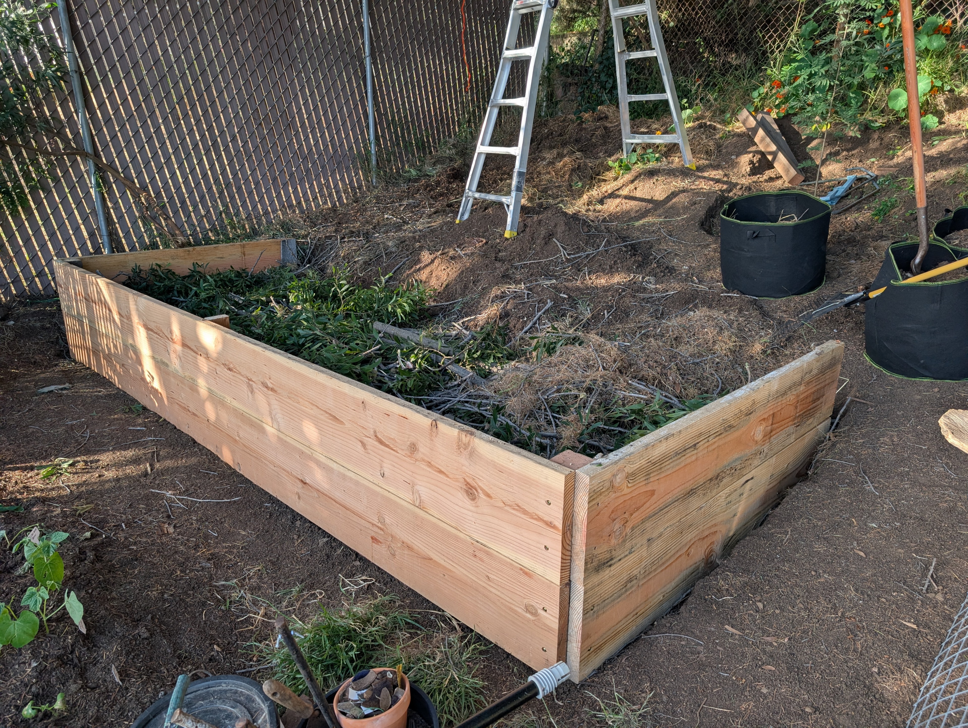 After cutting all the branches in smaller pieces, they compacted down pretty well. I'm sure there are tons of air gaps though I won't be able to fill well.