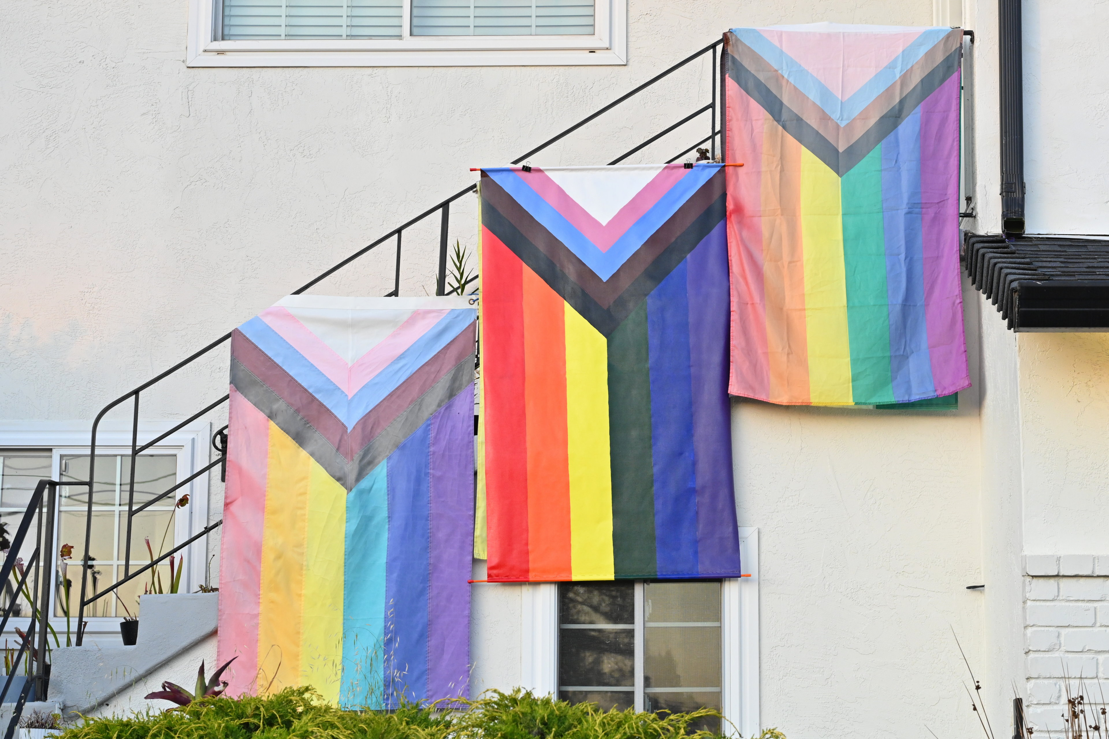 My newly painted pride flag between two sadly faded ones.